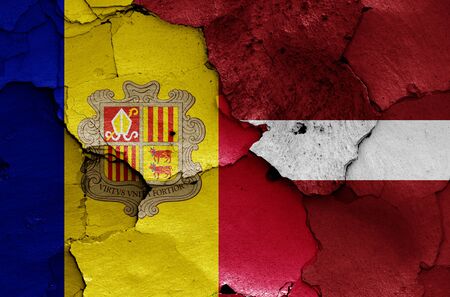 flags of Andorra and Latvia painted on cracked wallの写真素材