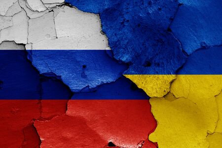 flags of Russia and Ukraine painted on cracked wallの写真素材