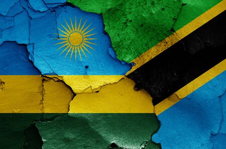 flags of Rwanda and Tanzania painted on cracked wallの写真素材