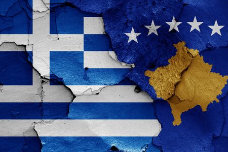 flags of Greece and Kosovo painted on cracked wallの写真素材