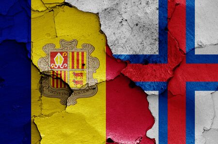 flags of Andorra and Faroe Islands painted on cracked wallの写真素材