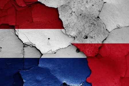flags of Netherlands and Poland painted on cracked wallの写真素材
