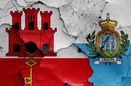 flags of Gibraltar and San Marino painted on cracked wallの写真素材