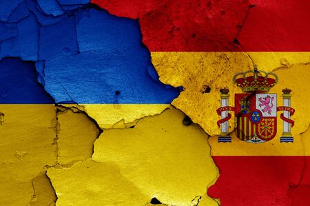 flags of Ukraine and Spain painted on cracked wallの写真素材