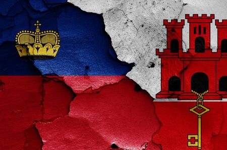 flags of Liechtenstein and Gibraltar painted on cracked wallの写真素材