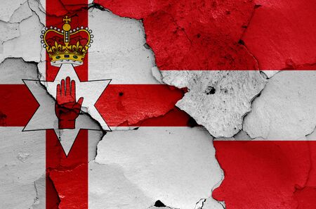flags of Northern Ireland and Austria painted on cracked wallの写真素材