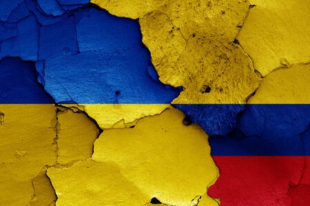 flags of Ukraine and Colombia painted on cracked wallの写真素材