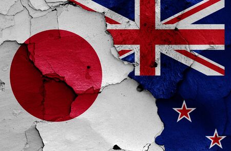 flags of Japan and New Zealand painted on cracked wallの写真素材