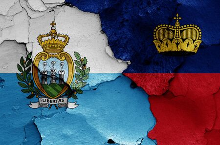 flags of San Marino and Liechtenstein painted on cracked wallの写真素材