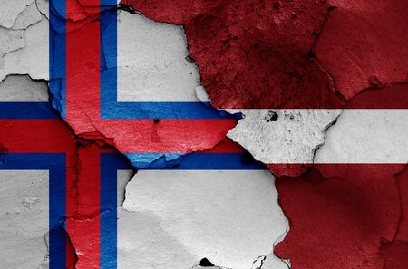 flags of Faroe Islands and Latvia painted on cracked wallの写真素材