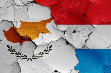 flags of Cyprus and Luxembourg painted on cracked wallの写真素材