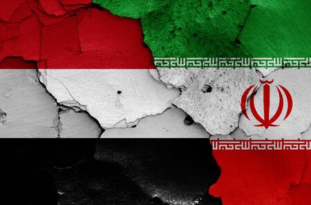 flags of Yemen and Iran painted on cracked wallの写真素材