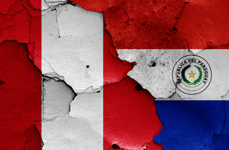 flags of Peru and Paraguay painted on cracked wallの写真素材