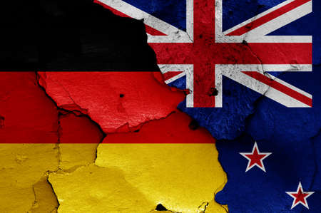 flags of Germany and New Zealand painted on cracked wallの写真素材