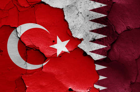 flags of Turkey and Qatar painted on cracked wallの写真素材