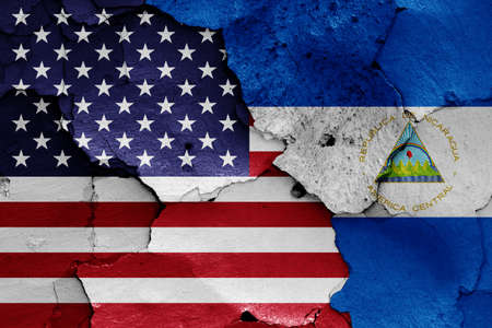 flags of USA and Nicaragua painted on cracked wallの写真素材