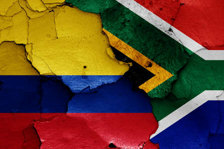 flags of Colombia and South Africa painted on cracked wallの写真素材