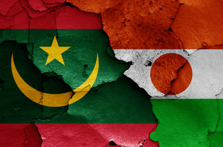 flags of Mauritania and Niger painted on cracked wallの写真素材