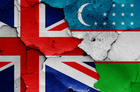 flags of UK and Uzbekistan painted on cracked wallの写真素材