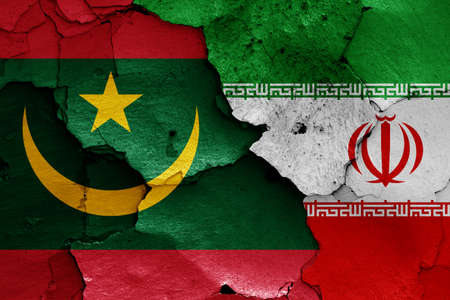 flags of Mauritania and Iran painted on cracked wallの写真素材