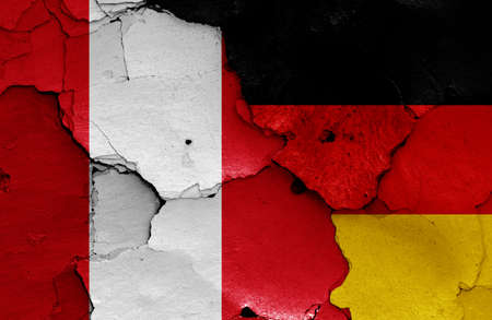 flags of Peru and Germany painted on cracked wallの写真素材