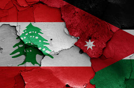 flags of Lebanon and Jordan painted on cracked wallの写真素材