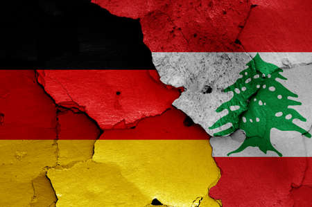 flags of Germany and Lebanon painted on cracked wallの写真素材