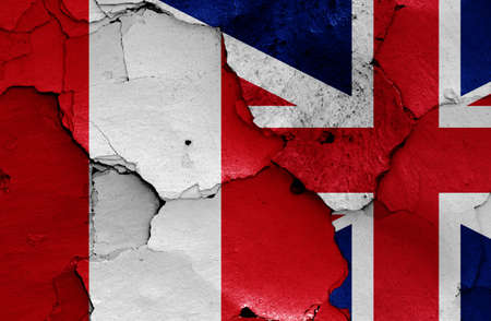 flags of Peru and UK painted on cracked wallの写真素材