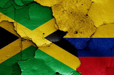 flags of Jamaica and Colombia painted on cracked wallの写真素材
