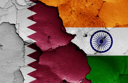 flags of Qatar and India painted on cracked wallの写真素材