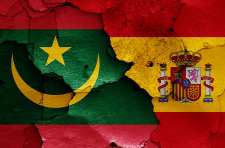 flags of Mauritania and Spain painted on cracked wallの写真素材