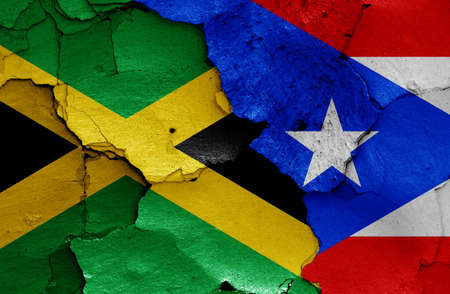 flags of Jamaica and Puerto Rico painted on cracked wallの写真素材
