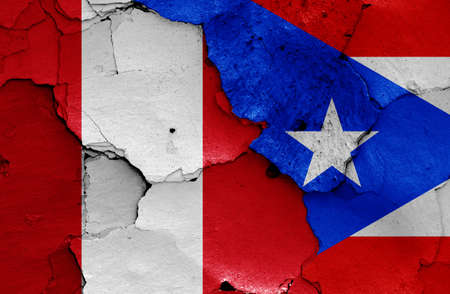 flags of Peru and Puerto Rico painted on cracked wallの写真素材