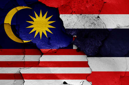 flags of Malaysia and Thailand painted on cracked wallの写真素材