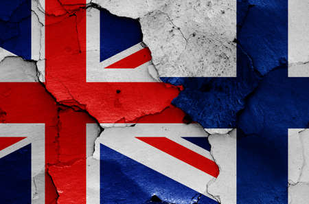 flags of UK and Finland painted on cracked wallの写真素材