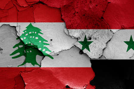 flags of Lebanon and Syria painted on cracked wallの写真素材