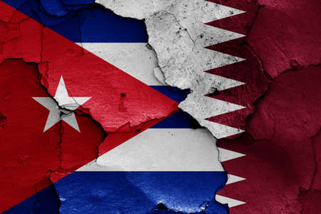 flags of Cuba and Qatar painted on cracked wallの写真素材