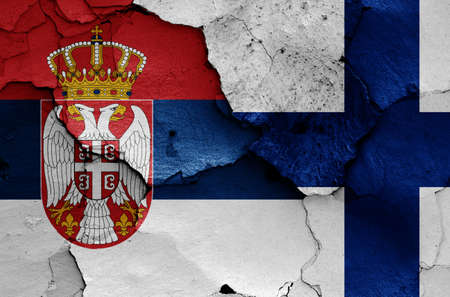 flags of Serbia and Finland painted on cracked wallの写真素材
