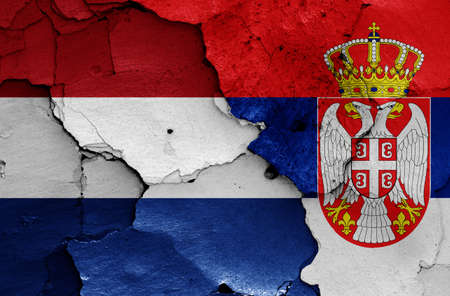 flags of Netherlands and Serbia painted on cracked wallの写真素材