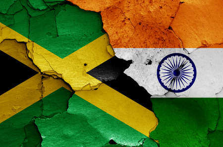 flags of Jamaica and India painted on cracked wallの写真素材