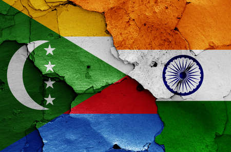 flags of Comoros and India painted on cracked wallの写真素材
