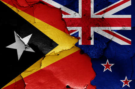 flags of East Timor and New Zealand painted on cracked wallの写真素材