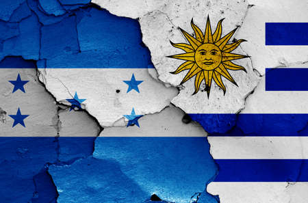 flags of Honduras and Uruguay painted on cracked wallの写真素材
