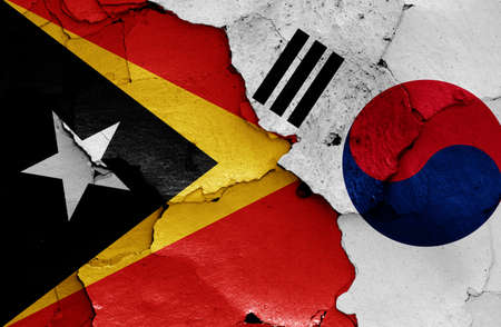 flags of East Timor and South Korea painted on cracked wallの写真素材