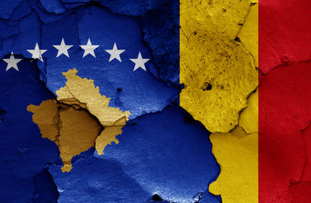flags of Kosovo and Romania painted on cracked wallの写真素材