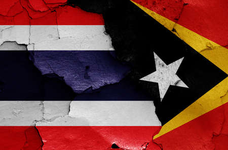 flags of Thailand and East Timor painted on cracked wallの写真素材