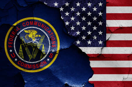 flags of Federal Communications Commission and USA painted on cracked wallの写真素材