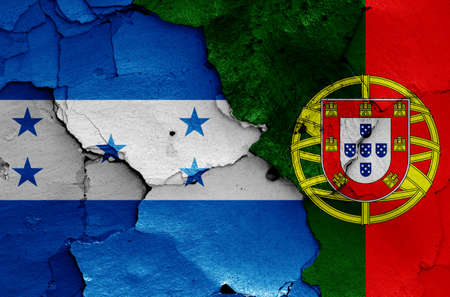 flags of Honduras and Portugal painted on cracked wallの写真素材