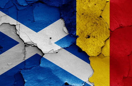 flags of Scotland and Romania painted on cracked wallの写真素材