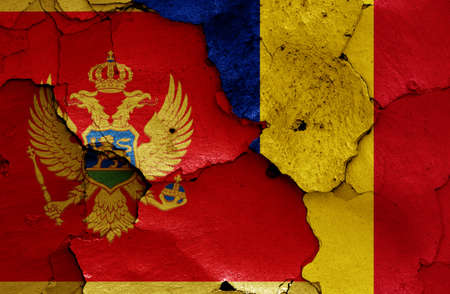 flags of Montenegro and Romania painted on cracked wallの写真素材